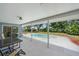 View of covered patio with pool, patio furniture and fenced backyard with mature trees at 3335 Meadow Run Ter, Venice, FL 34293