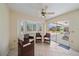 Bright sunroom featuring a ceiling fan, and a sliding glass door leading to an outdoor patio area at 3335 Meadow Run Ter, Venice, FL 34293