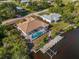 Aerial view of property, featuring a screened pool, boat dock, and direct waterfront access at 3620 Como St, Port Charlotte, FL 33948