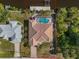 Expansive aerial view of tile-roofed home, screened pool, dock, and canal front in quiet neighborhood at 3620 Como St, Port Charlotte, FL 33948