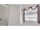 A bathroom with a large soaking tub and window dressed with decorative curtains and blinds at 3620 Como St, Port Charlotte, FL 33948