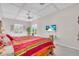 Bright bedroom with colorful bedding, ceiling fan, and a TV showing a tropical beach scene at 3620 Como St, Port Charlotte, FL 33948