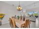 Elegant dining room featuring a decorative chandelier, seating for four, and view to the lanai at 3620 Como St, Port Charlotte, FL 33948