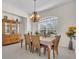Dining room with a traditional chandelier, wood table, and a large window with natural lighting at 3620 Como St, Port Charlotte, FL 33948