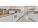 Clean kitchen with white cabinets, neutral counters, tiled flooring, and modern appliances at 3620 Como St, Port Charlotte, FL 33948
