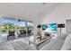 Bright living room with view of pool, featuring a comfortable sofa and modern entertainment center at 3620 Como St, Port Charlotte, FL 33948