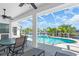 Enjoy outdoor dining on the covered patio overlooking the sparkling screened pool and waterway at 3620 Como St, Port Charlotte, FL 33948