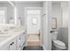 Well-lit bathroom with a double vanity, tile floors, and a view of a bedroom through an open doorway at 3702 5Th Ave, Holmes Beach, FL 34217