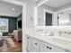 Elegant bathroom with dual sinks, quartz countertops, and modern fixtures. Bedroom view in background at 3702 5Th Ave, Holmes Beach, FL 34217