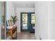 Bright entryway with blue french doors, tiled floors, and stylish console table with plants at 3702 5Th Ave, Holmes Beach, FL 34217