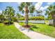Beautifully landscaped front yard with lush greenery, palm trees, and a charming walkway leading to the home at 3702 5Th Ave, Holmes Beach, FL 34217