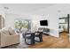 Bright living room with wood floors, comfortable seating, and sliding glass doors to an outdoor deck at 3702 5Th Ave, Holmes Beach, FL 34217