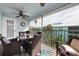 This screened balcony features four chairs, a table, ceiling fan, and a great view of the outdoors at 3703 5Th Ave # 3, Holmes Beach, FL 34217