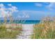 Inviting beach access framed by lush dunes and vegetation, leading to tranquil ocean views at 3703 5Th Ave # 3, Holmes Beach, FL 34217