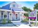 Charming Holmes Beach cottage with a quaint porch, American flag, and real estate signage at 3703 5Th Ave # 3, Holmes Beach, FL 34217
