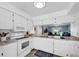 Well-lit kitchen featuring white appliances, wood-look flooring, and a view through to the living area at 3703 5Th Ave # 3, Holmes Beach, FL 34217