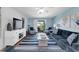 Bright living room with a ceiling fan, TV, and sliding glass doors to a balcony; decorated in a blue color scheme at 3703 5Th Ave # 3, Holmes Beach, FL 34217