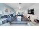 Spacious living room in a blue color scheme, adjacent to a kitchen and featuring a ceiling fan and stylish furniture at 3703 5Th Ave # 3, Holmes Beach, FL 34217