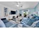 Cozy living room in a blue color scheme with a ceiling fan, artwork, sofa, chairs, and access to a balcony at 3703 5Th Ave # 3, Holmes Beach, FL 34217