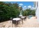 This covered patio includes tables and chairs adjacent to the outdoor pool and is surrounded by tropical greenery at 3703 5Th Ave # 3, Holmes Beach, FL 34217
