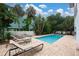 Private pool surrounded by lush tropical landscaping and lounge chairs for relaxing outdoors at 3703 5Th Ave # 3, Holmes Beach, FL 34217