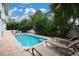 Inviting backyard pool with lounge chairs surrounded by tropical landscaping and a brick paved deck at 3703 5Th Ave # 3, Holmes Beach, FL 34217
