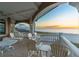 Wide balcony with white railings and outdoor seating overlooks a sandy beach and ocean sunset at 3800 Gulf Blvd # Ph, St Petersburg, FL 33706