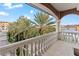 Balcony with white railings and pillars offering a view of palm trees and a street at 3800 Gulf Blvd # Ph, St Petersburg, FL 33706
