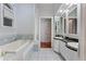 Luxurious bathroom with double sinks, large tub, and tiled floors at 3800 Gulf Blvd # Ph, St Petersburg, FL 33706