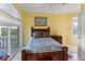Yellow bedroom with a tropical decor and sliding glass doors to a balcony overlooking palm trees and a beachfront at 3800 Gulf Blvd # Ph, St Petersburg, FL 33706