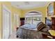 Yellow bedroom showcases a classic design with a sliding glass doors and an adjacent bathroom with a glass enclosed shower at 3800 Gulf Blvd # Ph, St Petersburg, FL 33706