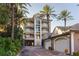 Stunning exterior view of a multi-story home with a private drive, balconies, garages, lush landscaping, and a grand entrance at 3800 Gulf Blvd # Ph, St Petersburg, FL 33706