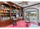 Home office with custom built-in bookshelves, traditional wood trim, and a sliding glass door to an outdoor balcony at 3800 Gulf Blvd # Ph, St Petersburg, FL 33706