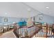 This spacious loft area features wood floors, a chandelier, a sitting area and white trim throughout at 3800 Gulf Blvd # Ph, St Petersburg, FL 33706