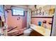 This charming bathroom features vintage pink tile, a shower-tub combination, and fun decorative elements at 409 Bryn Mawr Is, Bradenton, FL 34207