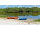 Two kayaks on a sandy bank by a calm river surrounded by lush trees, perfect for water adventures at 409 Bryn Mawr Is, Bradenton, FL 34207