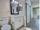 Bathroom with white vanity and framed mirror, next to a sliding door and bedroom at 4142 Central Sarasota Pkwy # 1423, Sarasota, FL 34238