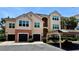 Charming condo building with a Spanish-tile roof, attached garages, and assigned carport parking at 4142 Central Sarasota Pkwy # 1423, Sarasota, FL 34238