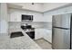Kitchen featuring white cabinets, stainless steel appliances, granite countertops, and plank flooring at 4142 Central Sarasota Pkwy # 1423, Sarasota, FL 34238