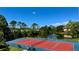 Scenic tennis court overlooking a lake with fountain and lush greenery at 4142 Central Sarasota Pkwy # 1423, Sarasota, FL 34238