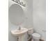 Well-lit bathroom featuring a pedestal sink, toilet, and an oval mirror at 4429 67Th E St, Bradenton, FL 34203