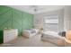 Bright bedroom featuring two twin beds, modern decor, and stylish green geometric accent wall at 4429 67Th E St, Bradenton, FL 34203