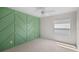 Clean bedroom showcasing a geometric-patterned green accent wall and ample natural light at 4429 67Th E St, Bradenton, FL 34203
