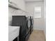 Laundry room featuring modern washer and dryer with utility sink and wire rack shelving at 4429 67Th E St, Bradenton, FL 34203