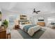 Main bedroom featuring tray ceiling, a ceiling fan, large bed and bedside tables at 4429 67Th E St, Bradenton, FL 34203