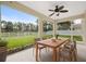 Covered patio with a dining table and chairs, overlooking the green lawn, garden, and pond at 4429 67Th E St, Bradenton, FL 34203