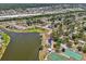 Scenic aerial view featuring homes near a lake, playground, tennis courts, and a shopping center in the distance at 4468 Maraldo Ave, North Port, FL 34287