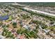 Aerial view of a residential neighborhood with mature trees, canal and a glimpse of a commercial area at 4468 Maraldo Ave, North Port, FL 34287