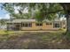 Backyard featuring a large tree, lush green grass and shrubbery, and a home's exterior at 4468 Maraldo Ave, North Port, FL 34287
