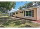 Home's backyard featuring a screened patio, lush green grass, trees, and shrubbery at 4468 Maraldo Ave, North Port, FL 34287